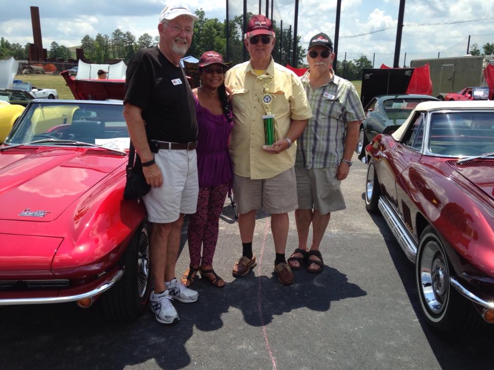 Beachcombers Members Stand and Smile in front of their Corvettes